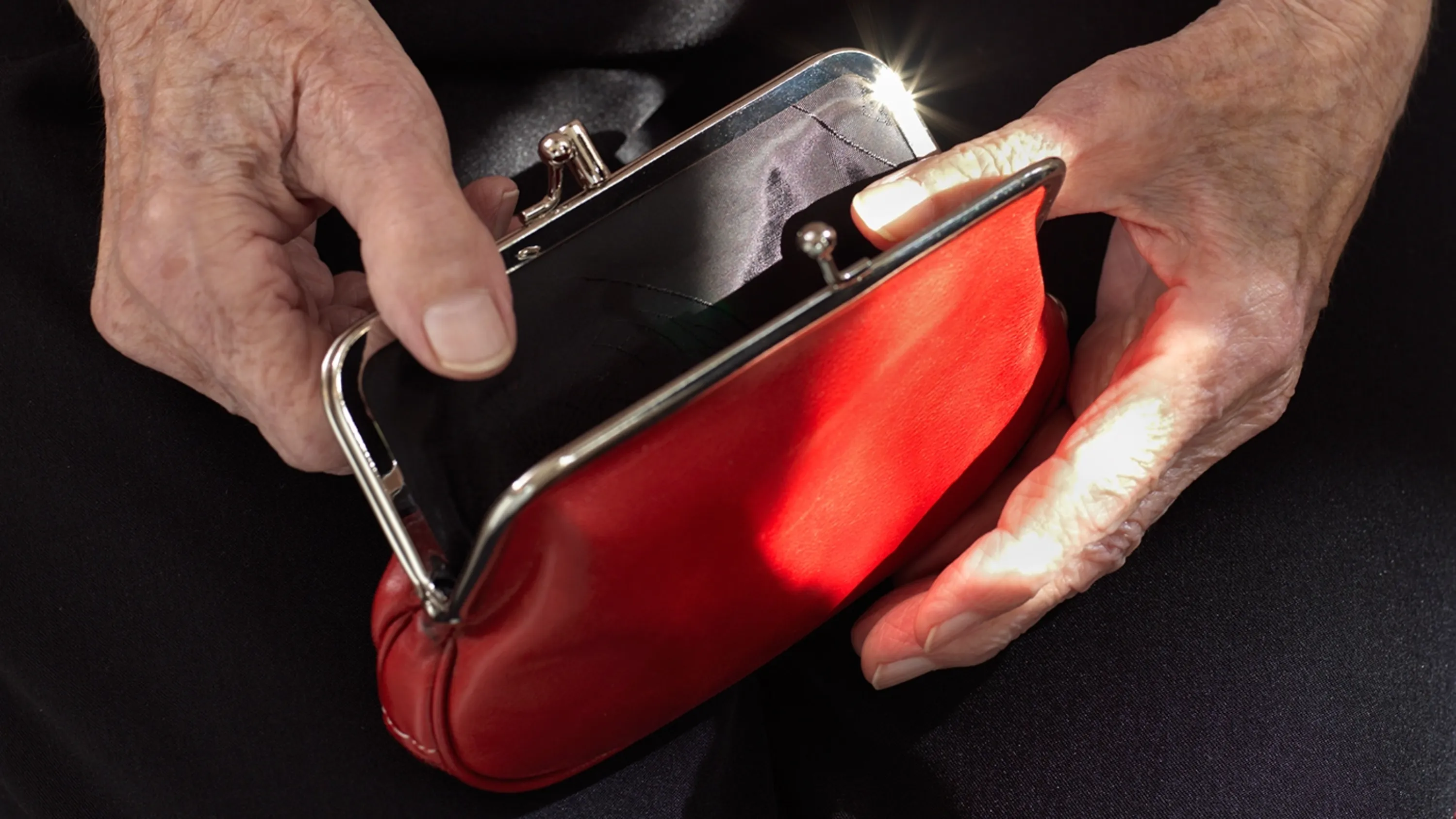 Mains d'une personnes âgées ouvrant un porte monnaie