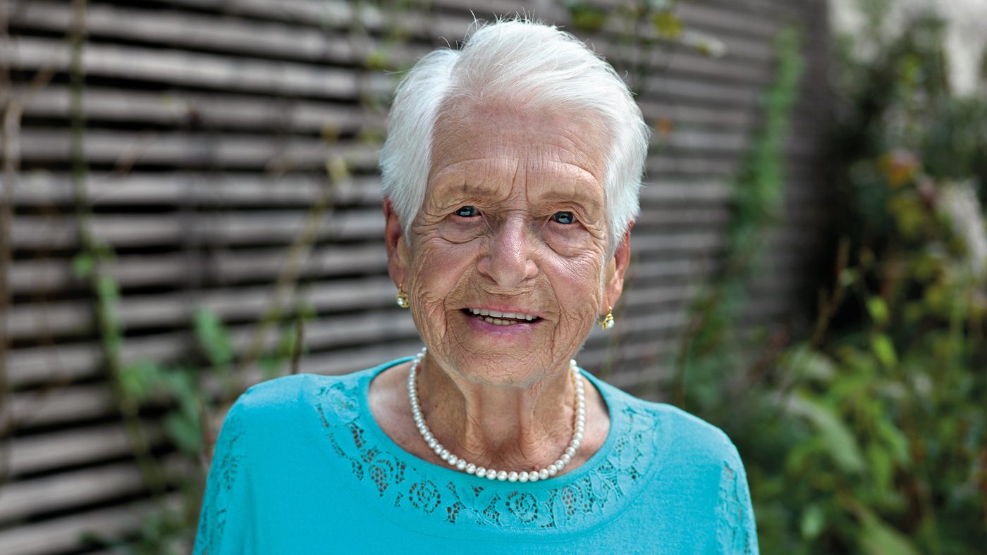 Une dame âgée sourit à la caméra