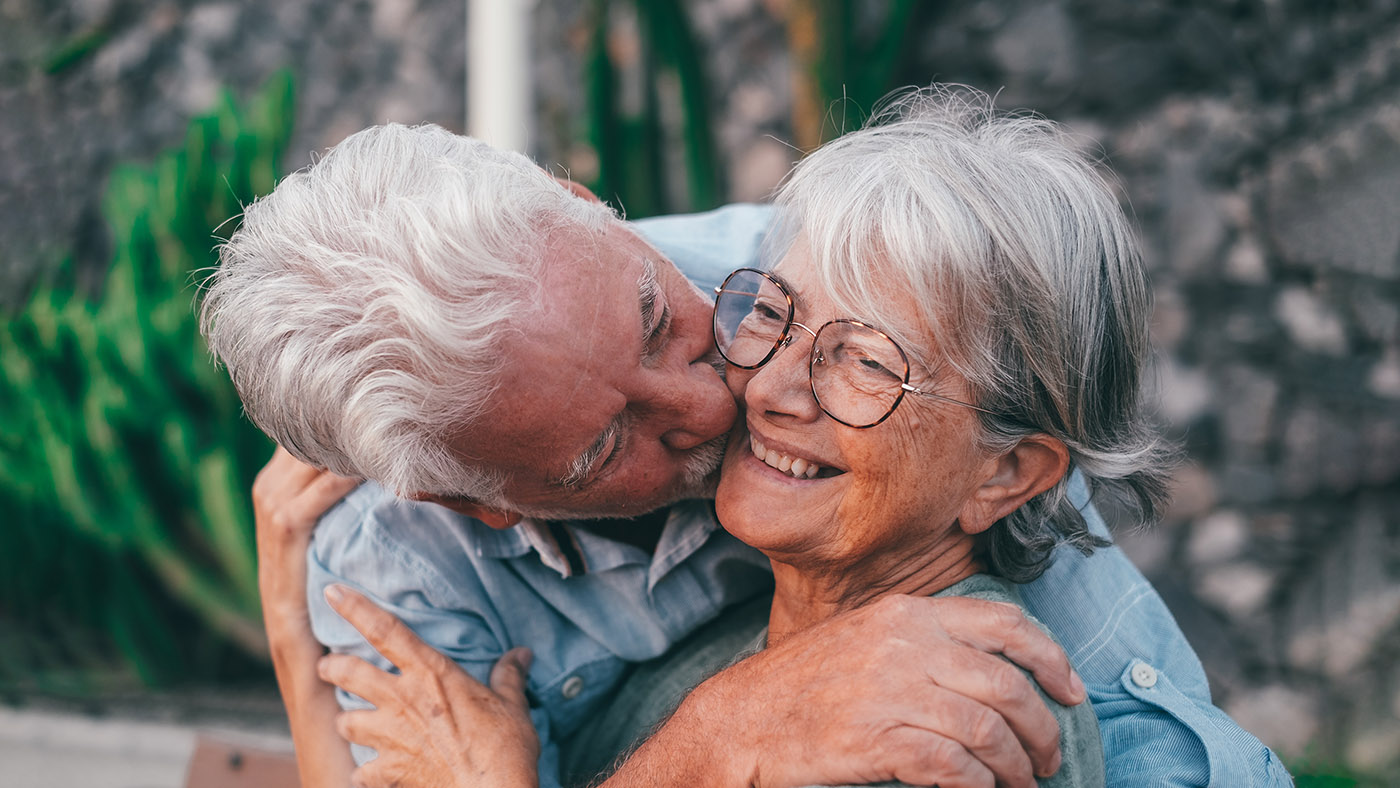 Ein Seniorin küsst seine Frau auf die Wange