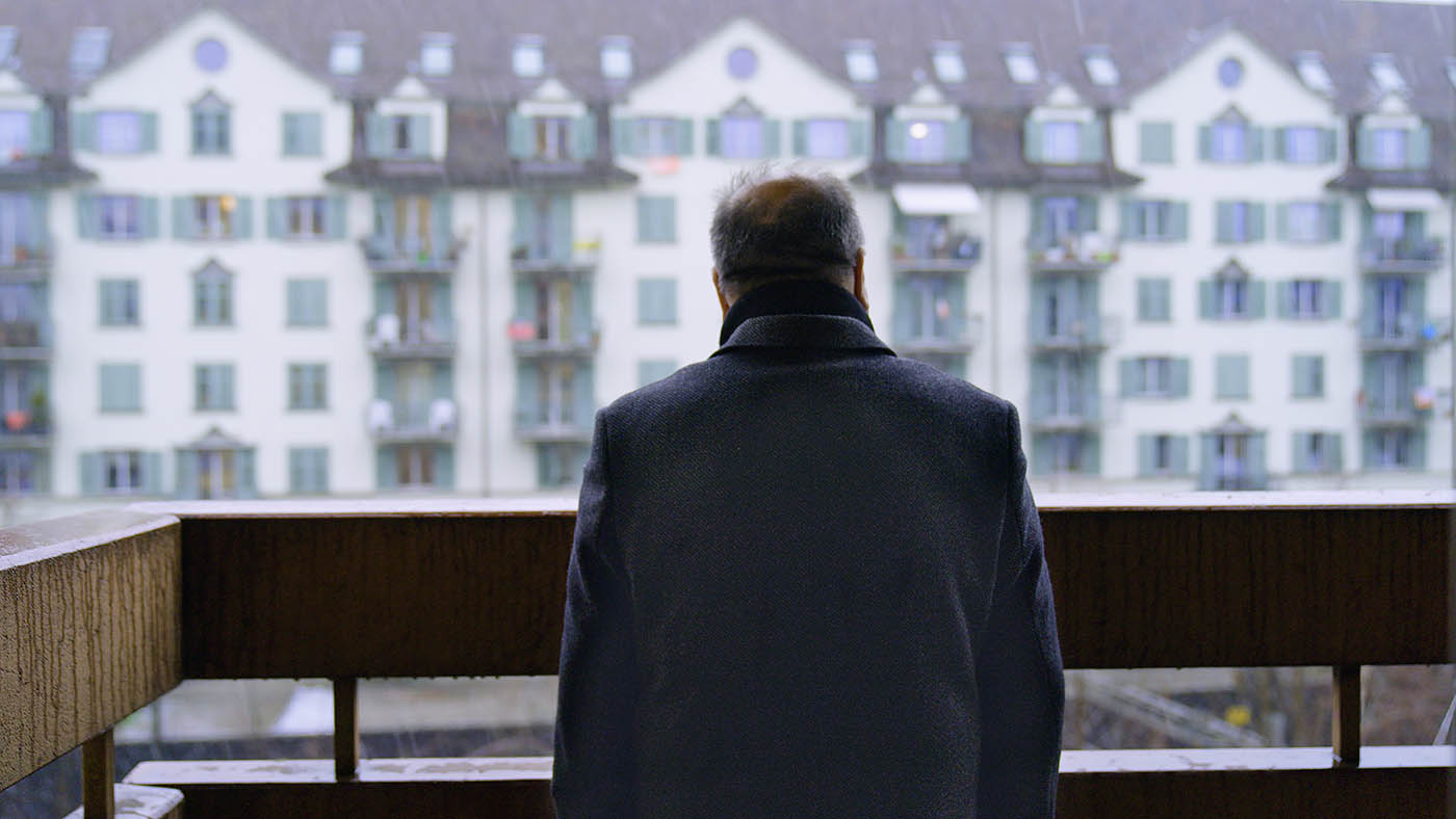 Mann steht alleine auf einem Balkon 